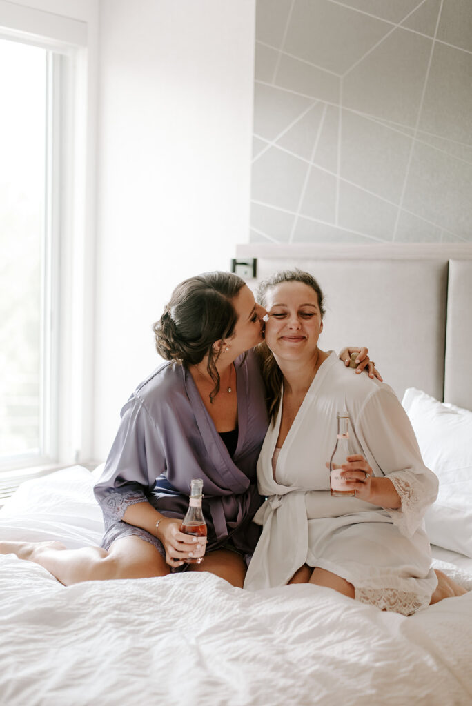 bridal party getting ready on bed in purple silk robes