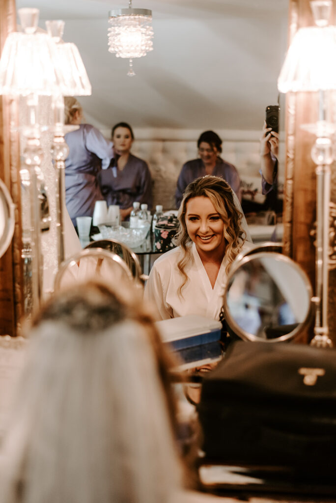 Bride looking in mirror and smiling