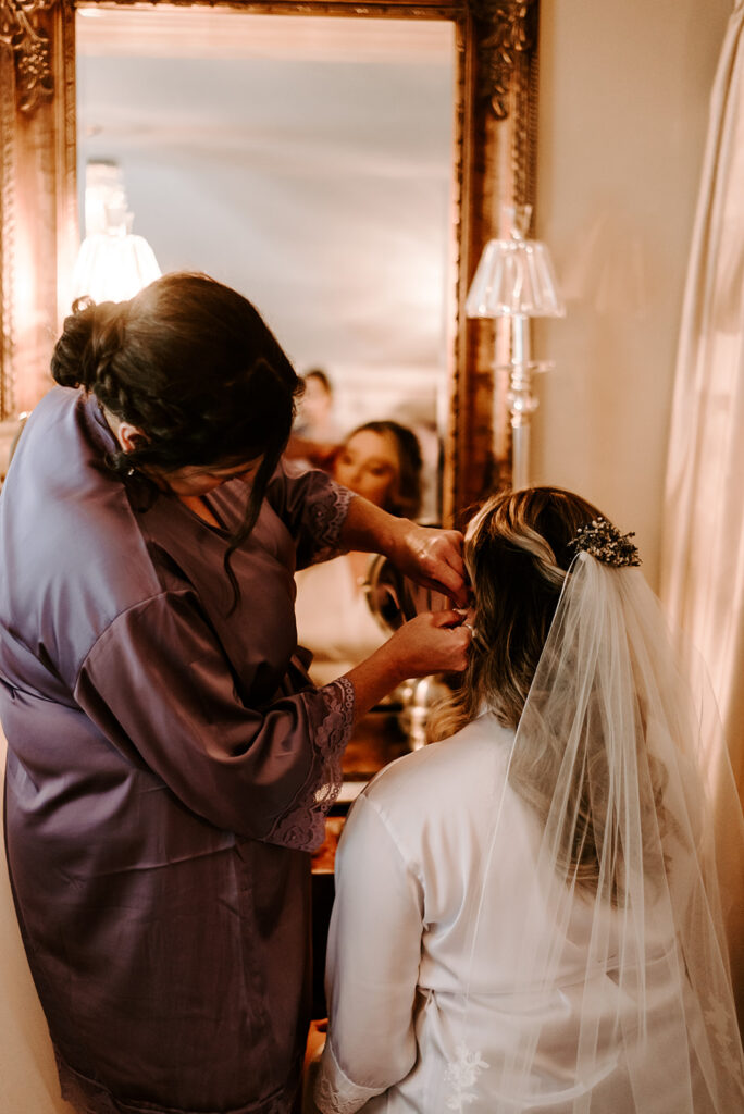 mother of the bride putting on her earrings