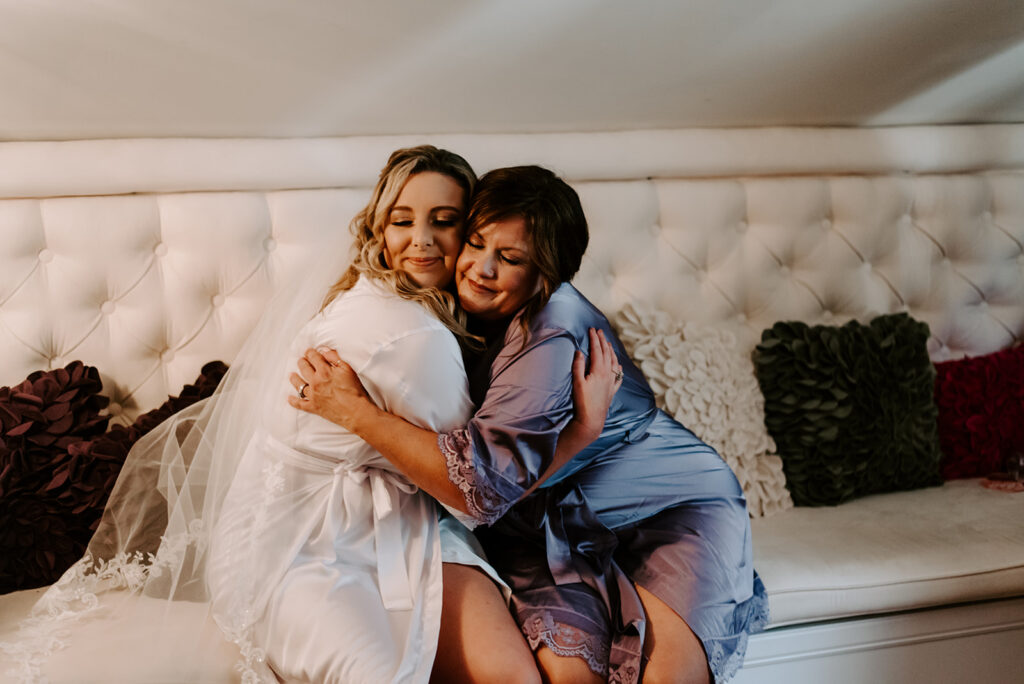 mother of the groom hugging the bride in bridal suite