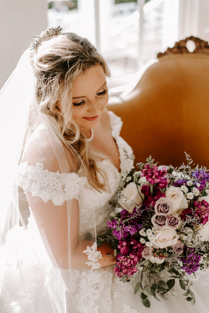 bride looking down smiling at flowers at Naylor Hall