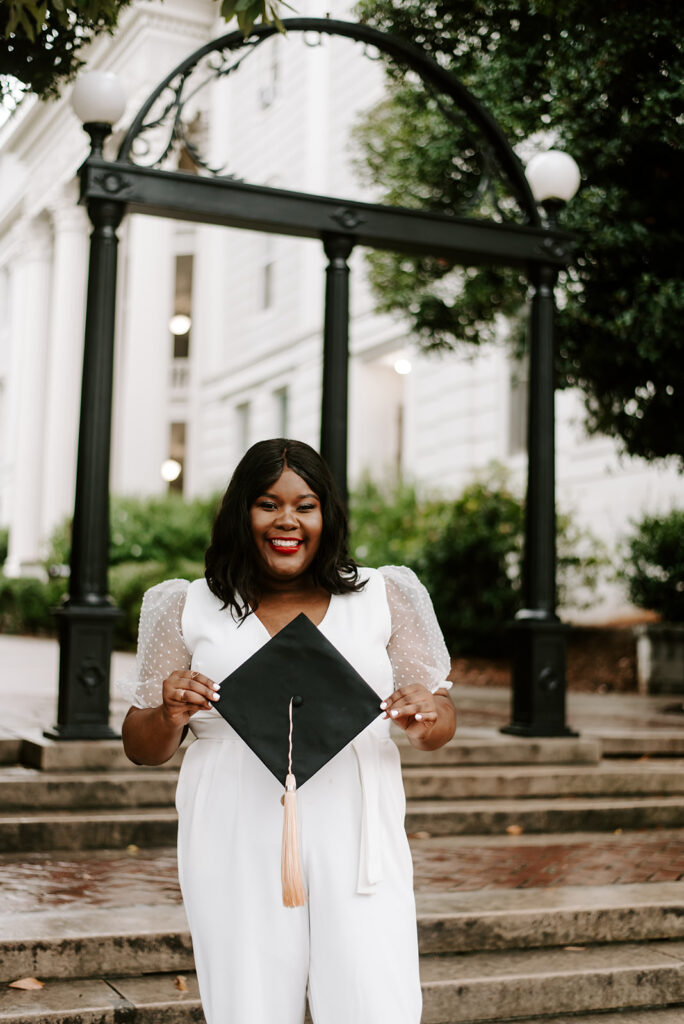 graduate holding cap outside of the arch