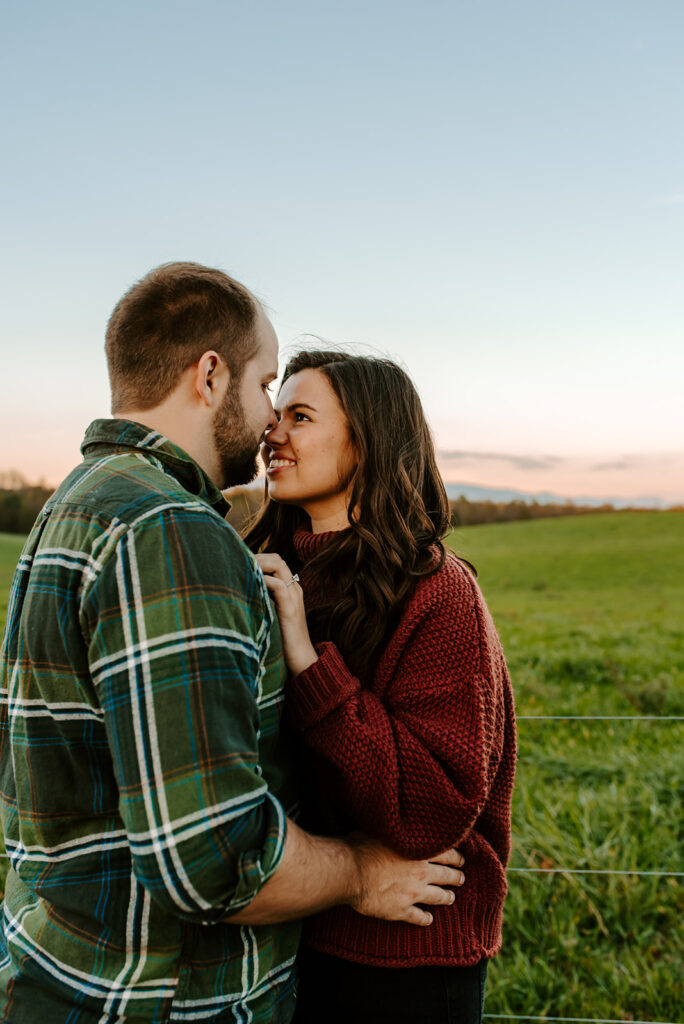 engaged couple looking into each other's eyes in a field
