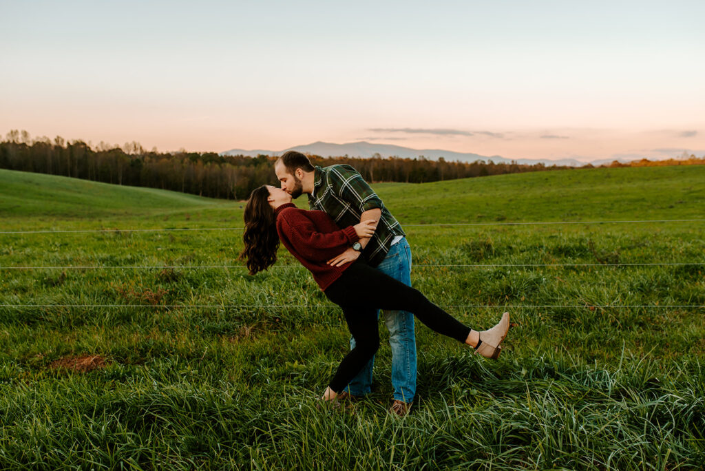 engaged couple kissing with mountains back drop in North Georgia
