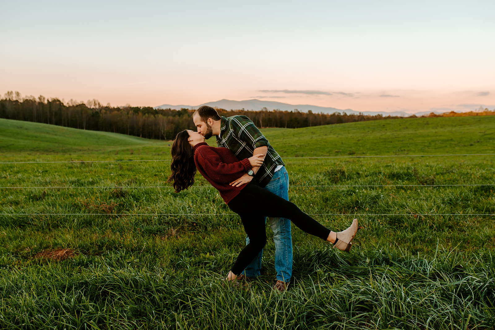 engaged couple kissing with mountains back drop in North Georgia