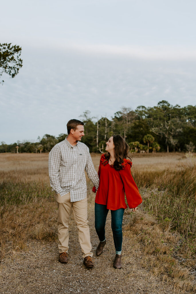 couple walking and laughing together at skidaway island for their engagement session