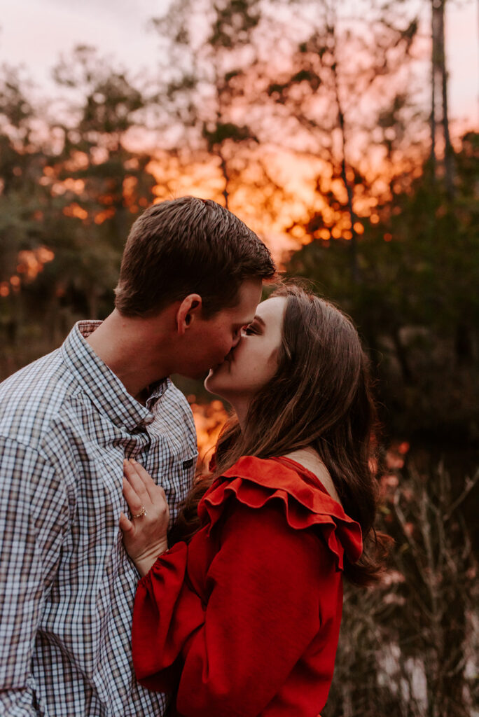 engaged couple kissing during sunset at skidaway island engagement session
