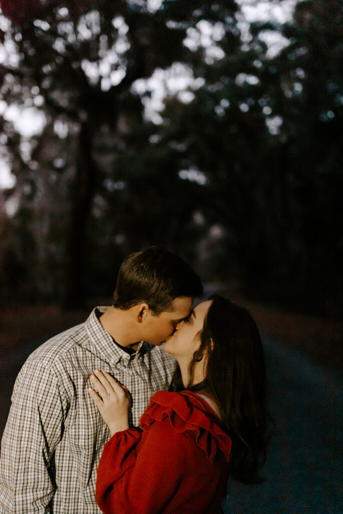 engaged couple kissing during blue hour at skidaway island engagement session