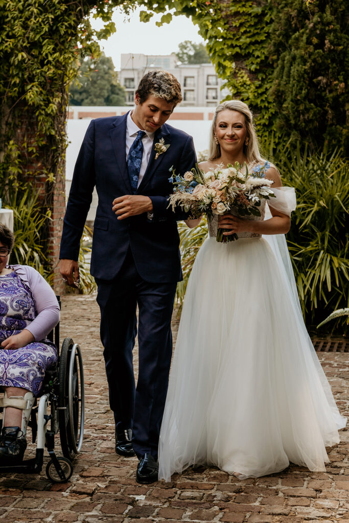 man in blue suit walking the bride down the aisle at summerour studio
