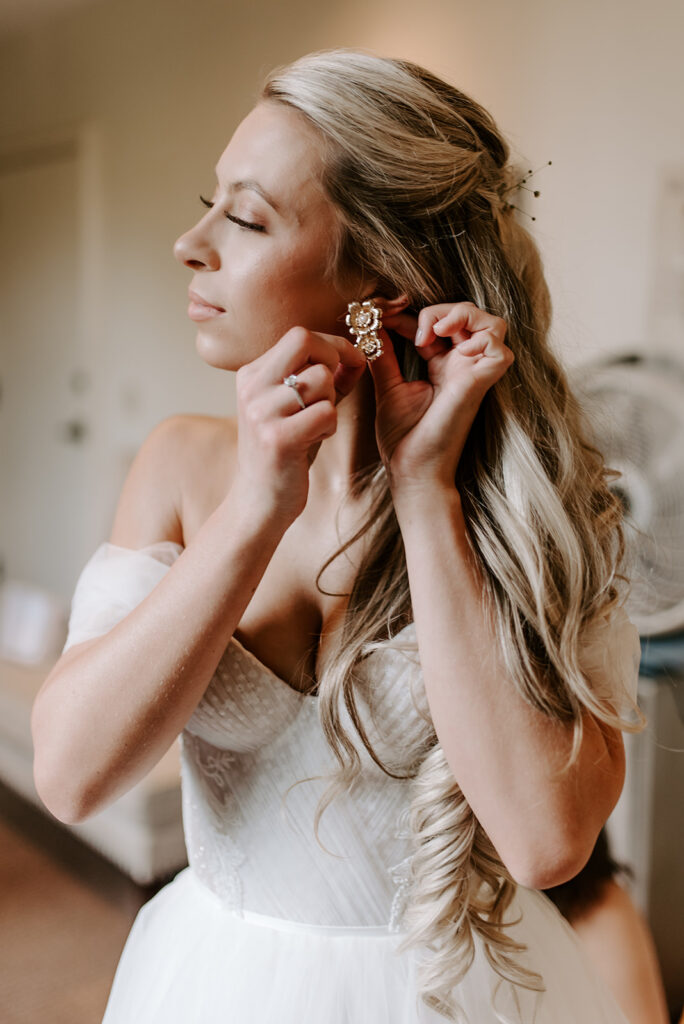 bride putting on her earrings at summerour studio
