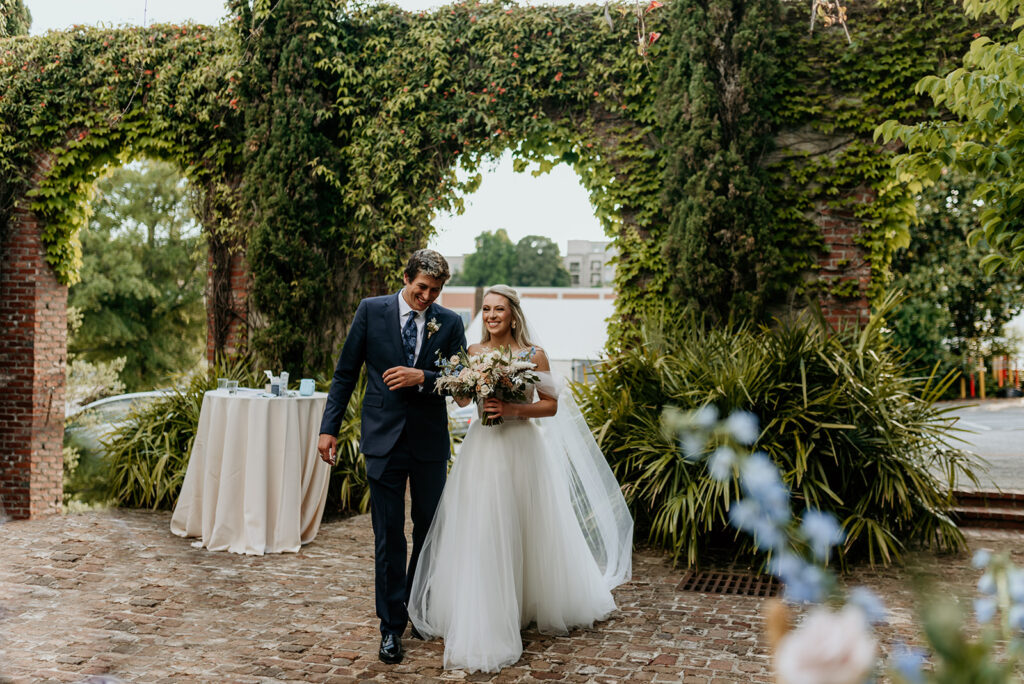 brother of the bride walking her down the aisle in a blue suit