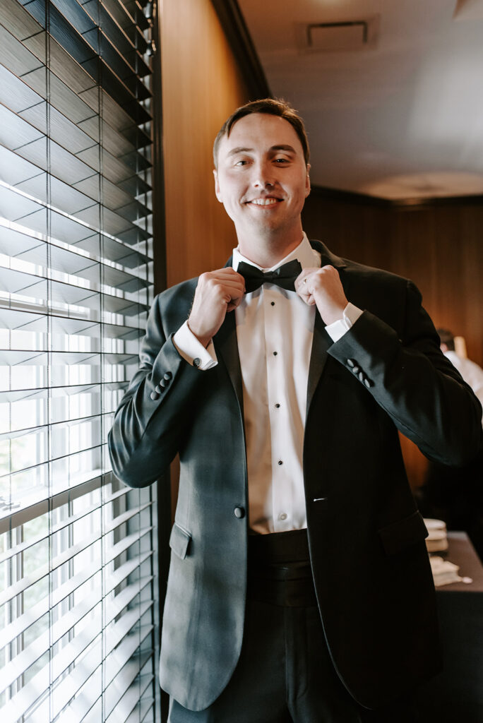 groom putting on bowtie at the reserve club