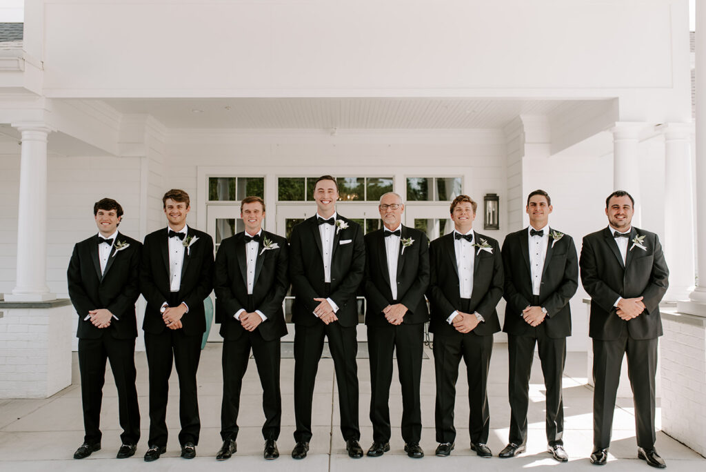 groomsmen all wearing black tuxes at the reserve club
