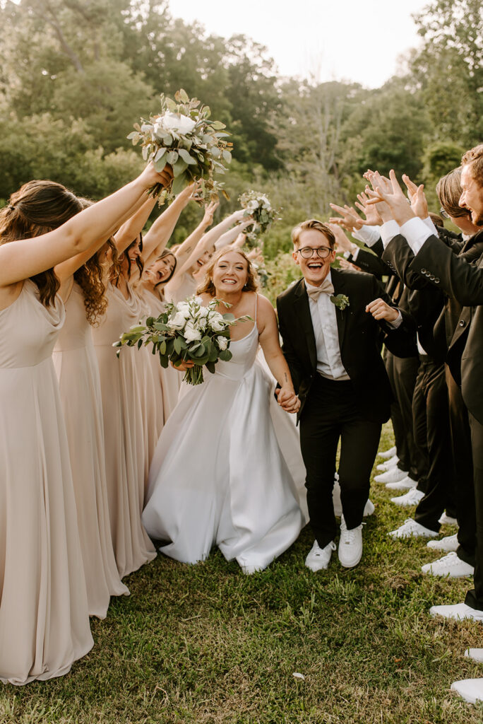 bridal party cheering on bride and groom for wedding at factory at walton mill