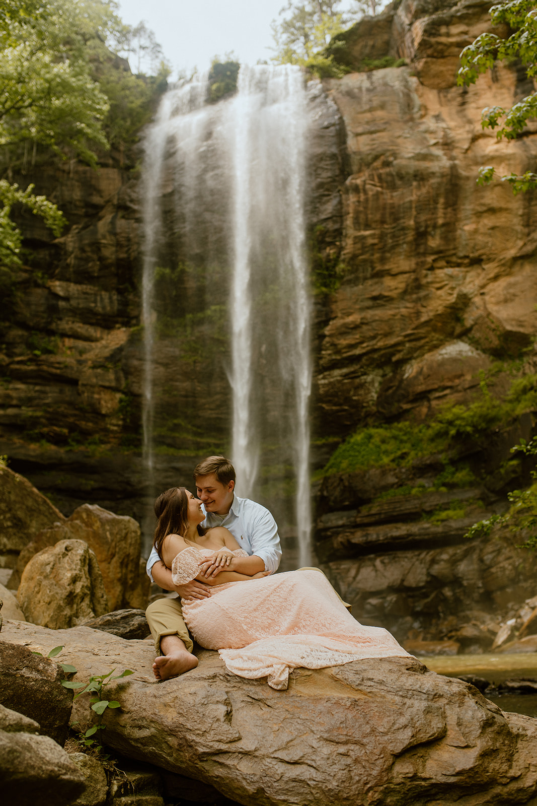 couple sitting and kissing in front of toccoa falls