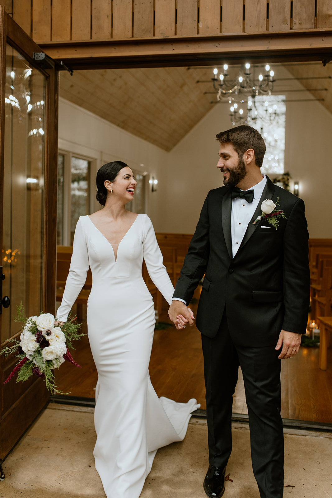 bride and groom walking hand in hand smiling